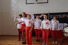 uczniowie-klasy-5-ubrani-na-bialo-czerwono-spiewaja-piesn-patriotyczna