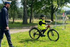 Policjant-kontrolujacy-przejazd-chlopca-pokonujacego-wyznaczona-trase
