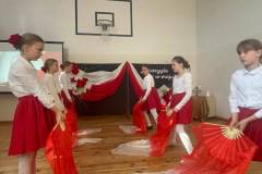 Dziewczynki-ubrane-w-biale-bluzki-i-czerwone-spodnice-tancza-z-wachlarzami-w-patriotycznych-kolorach