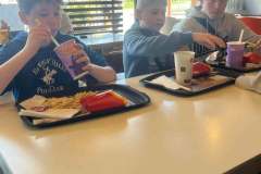 Troje-uczestnikow-wycieczki-podczas-posilku-w-restauracji-MCdonalds
