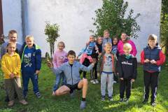 Uczestnicy-zielonego-wolontariatu-pozuja-do-wspolnego-zdjecia-przed-budynkiem-szkoly